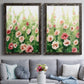 Set of two black barnwood framed canvas prints depicting paired luminous impressionistic floral paintings with loose blossoms, green stems, and sunlit watercolor texture above a sofa in a contemporary living room.
