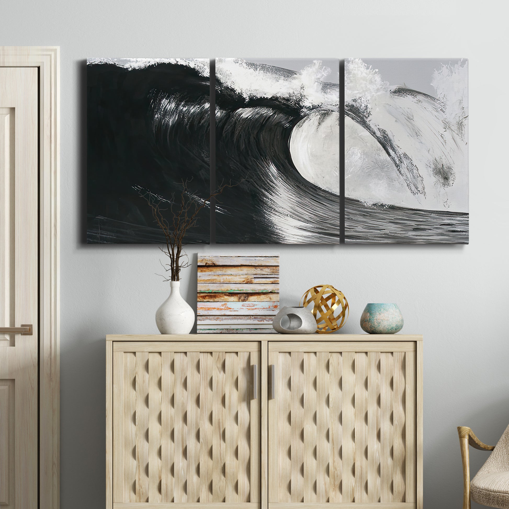 Three-panel canvas wall art featuring black and white crashing ocean waves, displayed above a cabinet in an entryway.