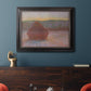 Impressionist haystack sunset scene in winter by Claude Monet in an ornate black frame with gilded inner detail displayed in a dark-toned interior setting.