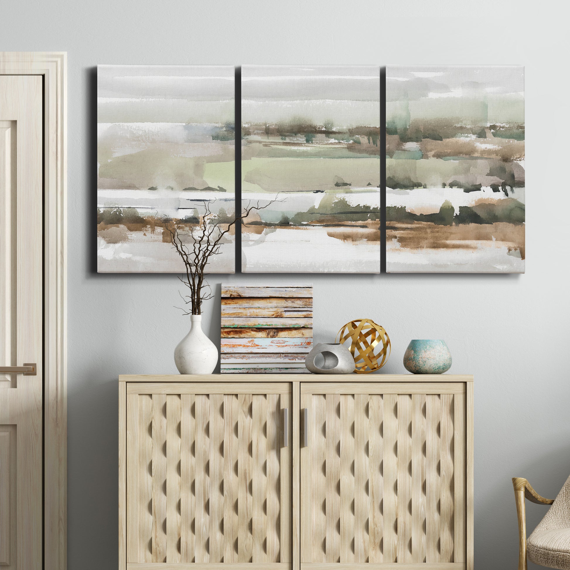 Three-panel canvas wall art featuring layered turquoise and earth tones abstract, displayed above a cabinet in an entryway.