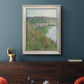 Impressionist landscape view of Vétheuil by Claude Monet in an ornate champagne frame displayed in a dark-toned interior setting.