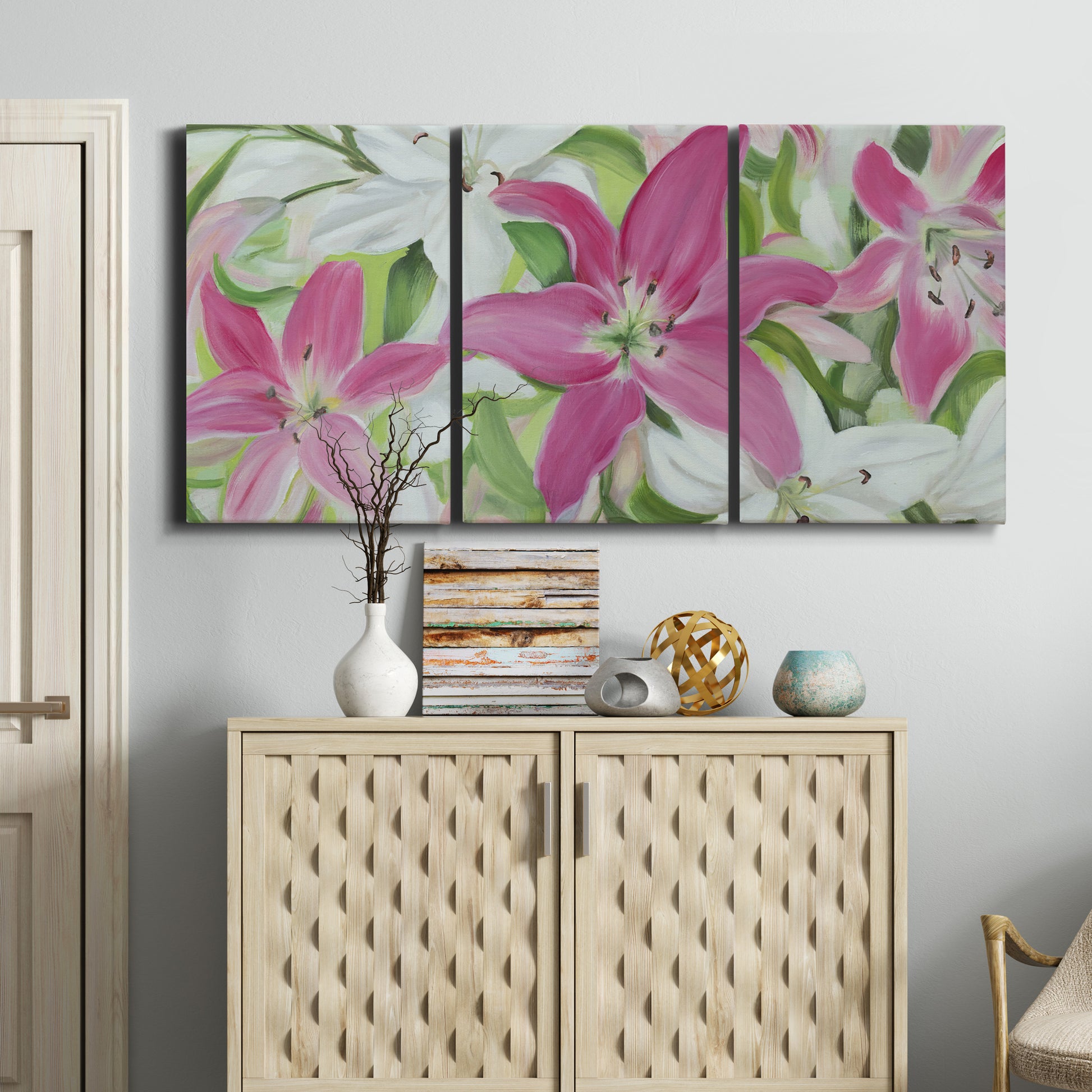 Three-panel canvas wall art featuring pink and white lilies in bloom, displayed above a cabinet in an entryway.