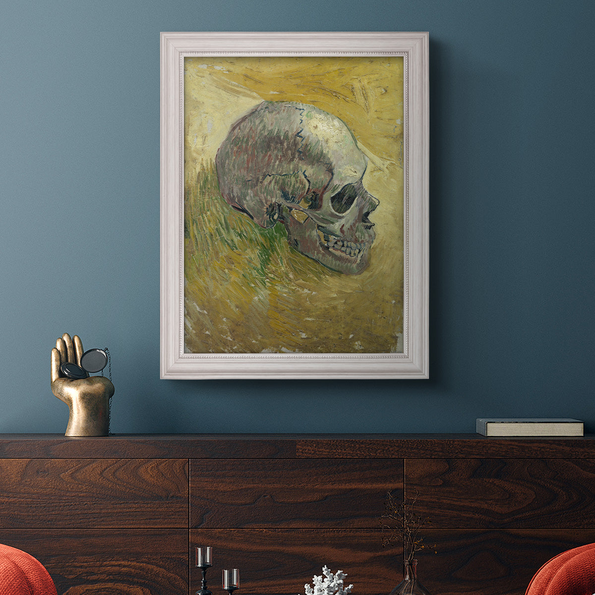 Profile skull study artwork by Vincent van Gogh in an ornate weathered white frame displayed in a dark-toned interior setting.