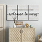 Three-panel canvas wall art featuring tropical beach at sunset photograph, displayed above a cabinet in an entryway.