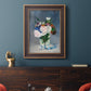 Impressionist floral still life painting by Claude Monet in an ornate bronzed mahogany wood frame displayed in a dark-toned interior setting.