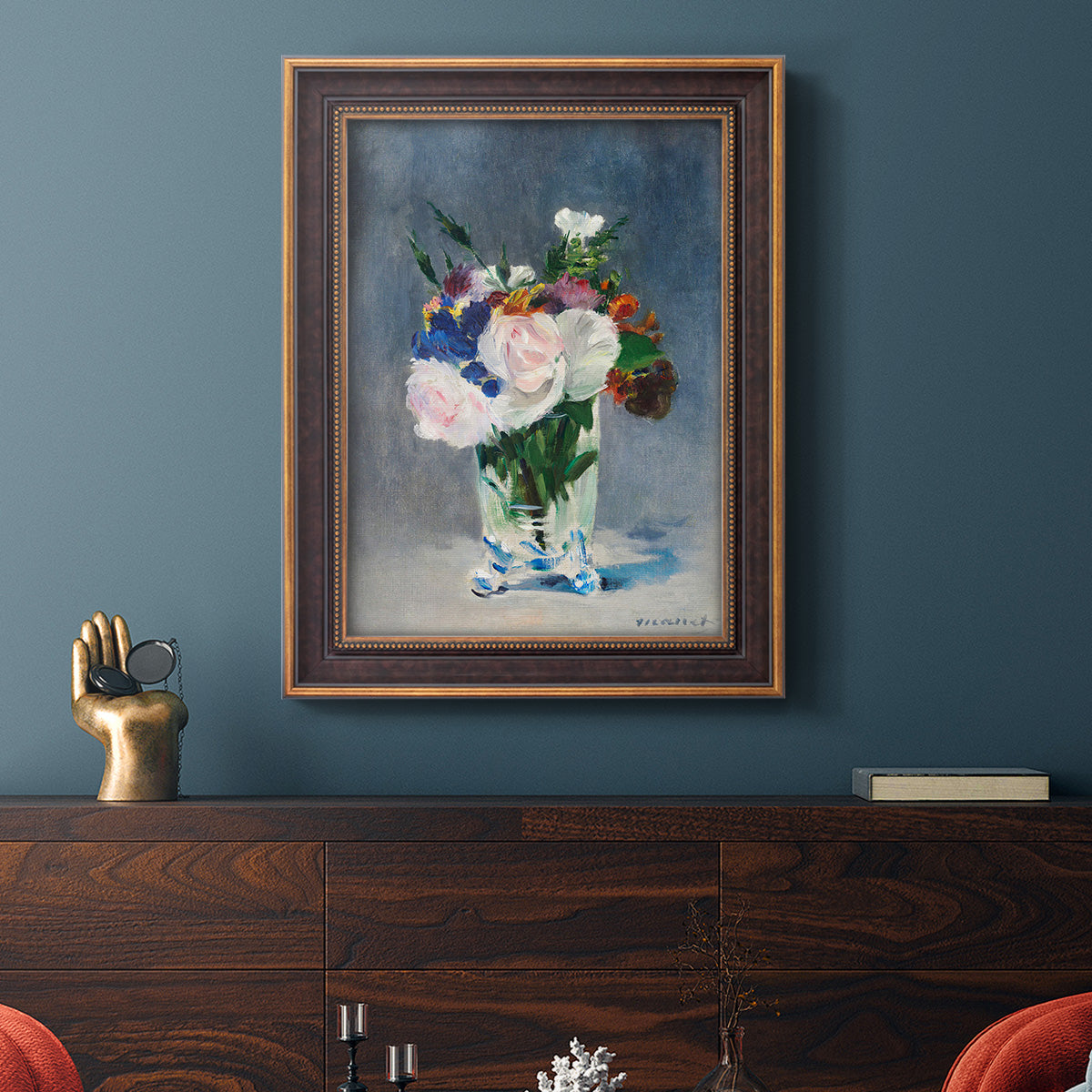 Impressionist floral still life painting by Claude Monet in an ornate bronzed mahogany wood frame displayed in a dark-toned interior setting.