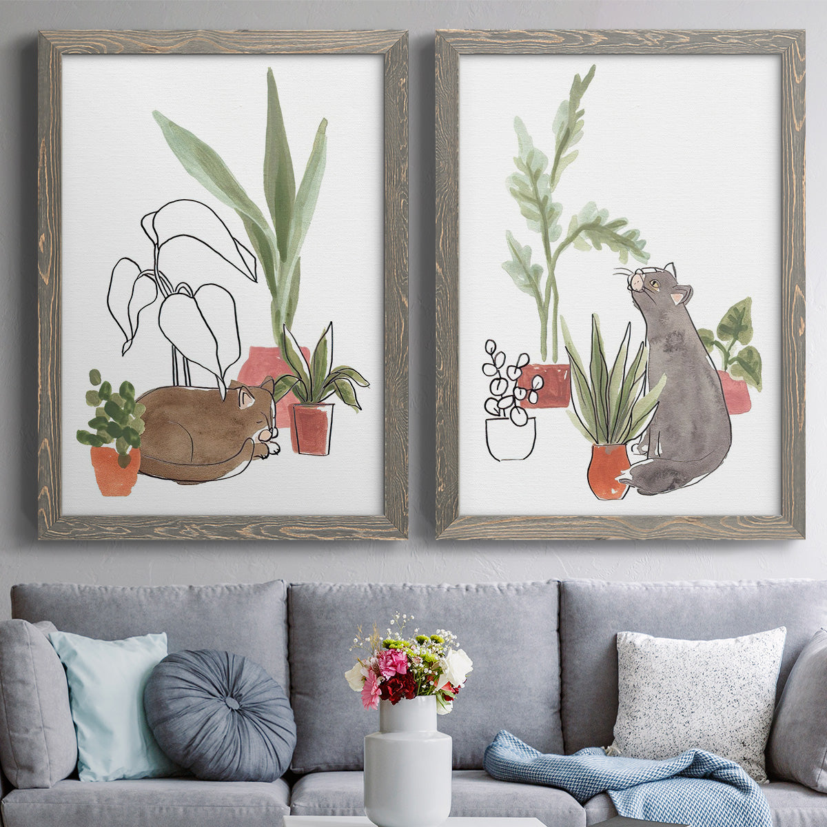 Set of two gray barnwood framed canvas prints depicting paired whimsical botanical animal illustrations with curious felines, terracotta pots, succulents, and leafy stems above a sofa in a contemporary living room.