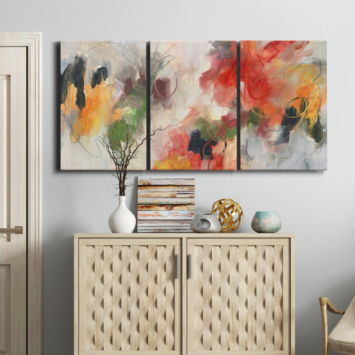 Three-panel canvas wall art featuring abstract floral color composition, displayed above a cabinet in an entryway.