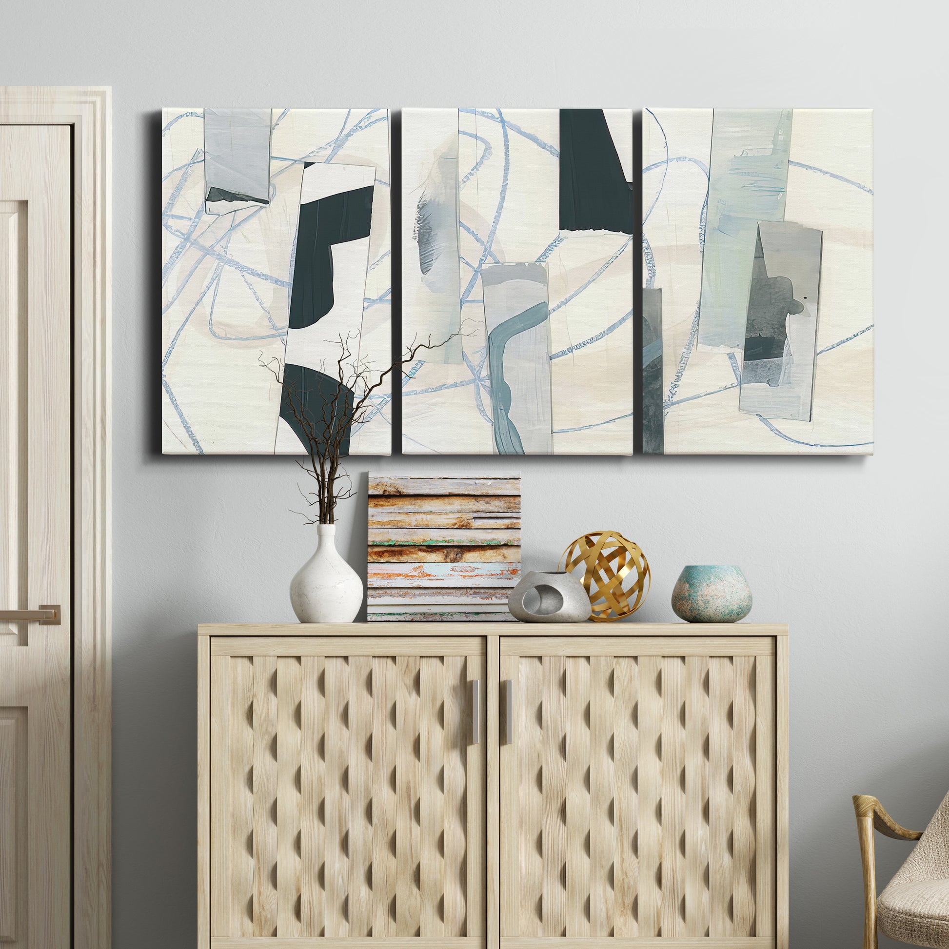 Three-panel canvas wall art featuring interwoven icy abstract linear forms, displayed above a cabinet in an entryway.