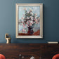 Impressionist chrysanthemum floral painting by Claude Monet in an ornate champagne frame displayed in a dark-toned interior setting.