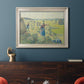Impressionist rural hay harvest landscape by Camille Pissarro in an ornate champagne frame displayed in a dark-toned interior setting.