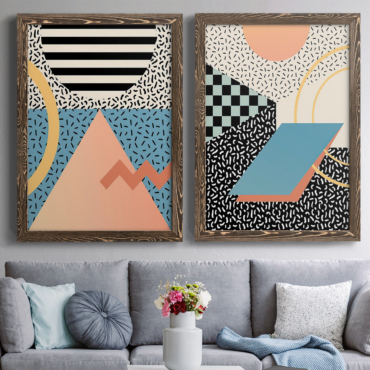 Set of two walnut barnwood framed canvas prints depicting paired retro graphic abstracts with checkerboards stripes squiggles peach blue black and mint shapes above a sofa in a contemporary living room.