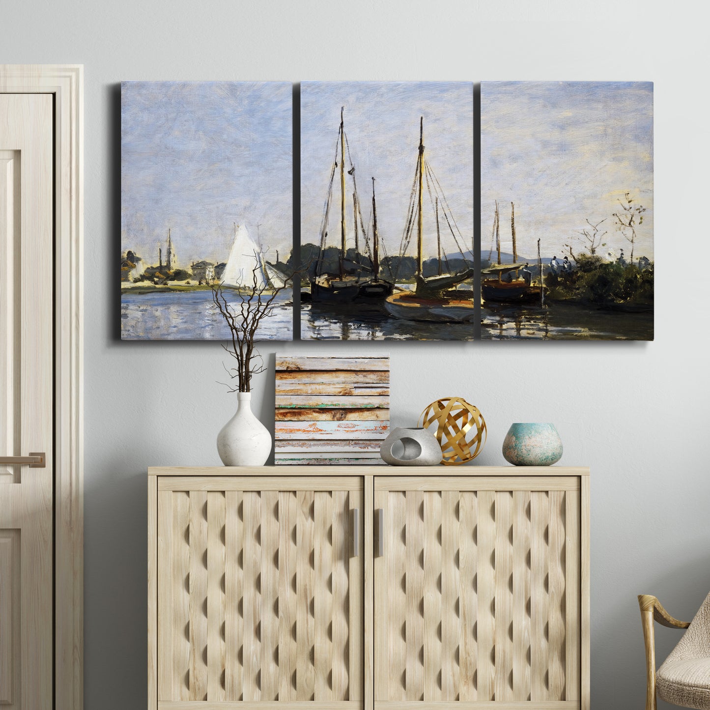 Three-panel canvas wall art featuring small pleasure boats on calm water, displayed above a cabinet in an entryway.