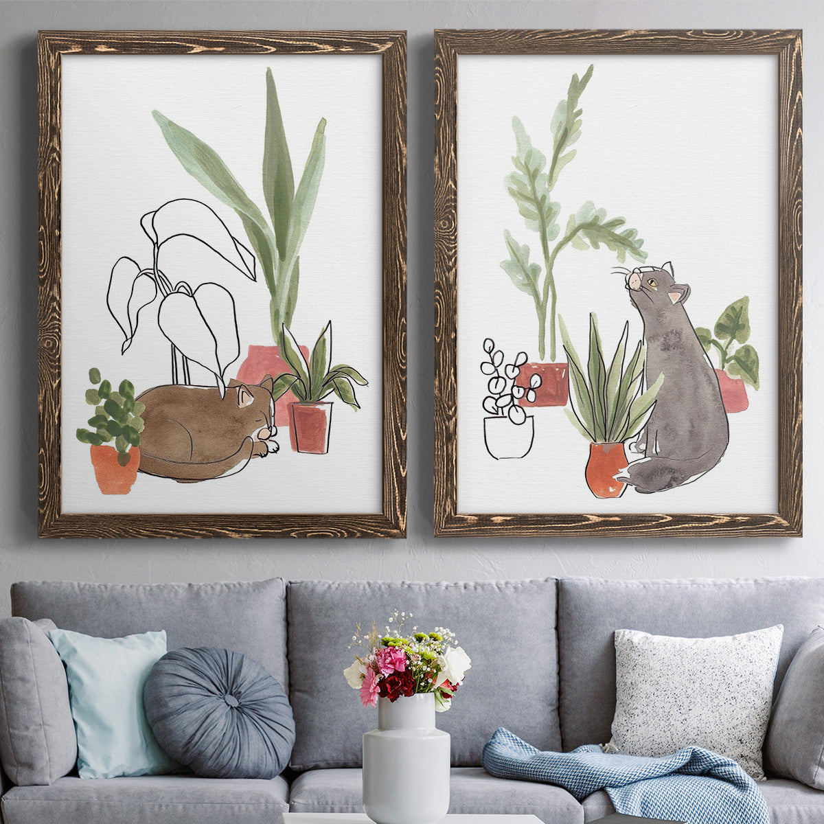 Set of two walnut barnwood framed canvas prints depicting paired whimsical botanical animal illustrations with curious felines, terracotta pots, succulents, and leafy stems above a sofa in a contemporary living room.