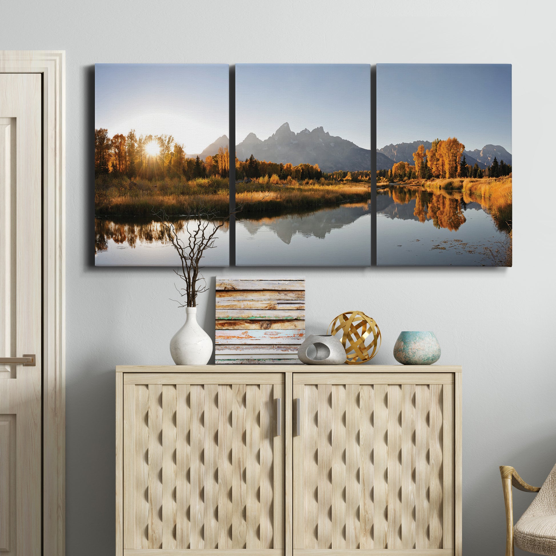 Three-panel canvas wall art featuring river canyon landscape photograph, displayed above a cabinet in an entryway.