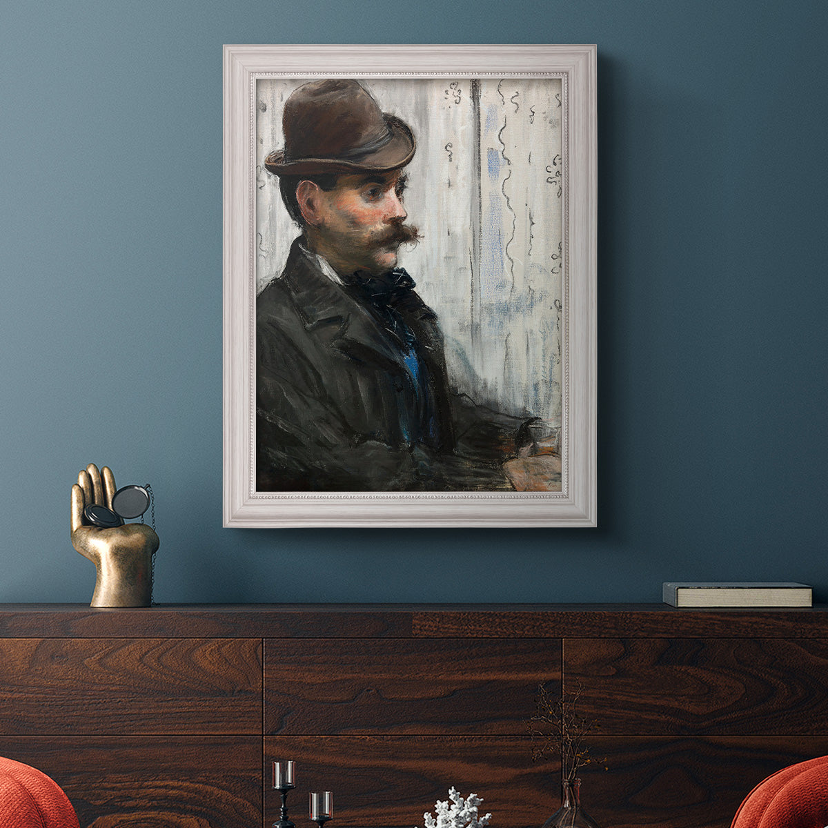 Impressionist portrait of a seated man by Édouard Manet in an ornate weathered white frame displayed in a dark-toned interior setting.