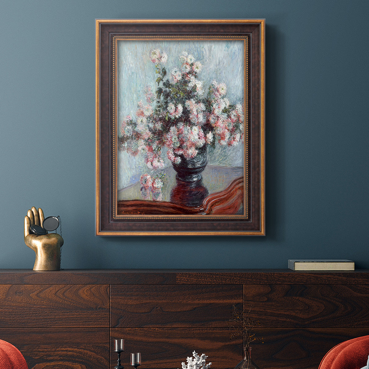 Impressionist chrysanthemum floral painting by Claude Monet in an ornate bronzed mahogany wood frame displayed in a dark-toned interior setting.