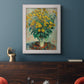 Impressionist floral painting of artichoke flowers by Claude Monet in an ornate weathered white frame displayed in a dark-toned interior setting.