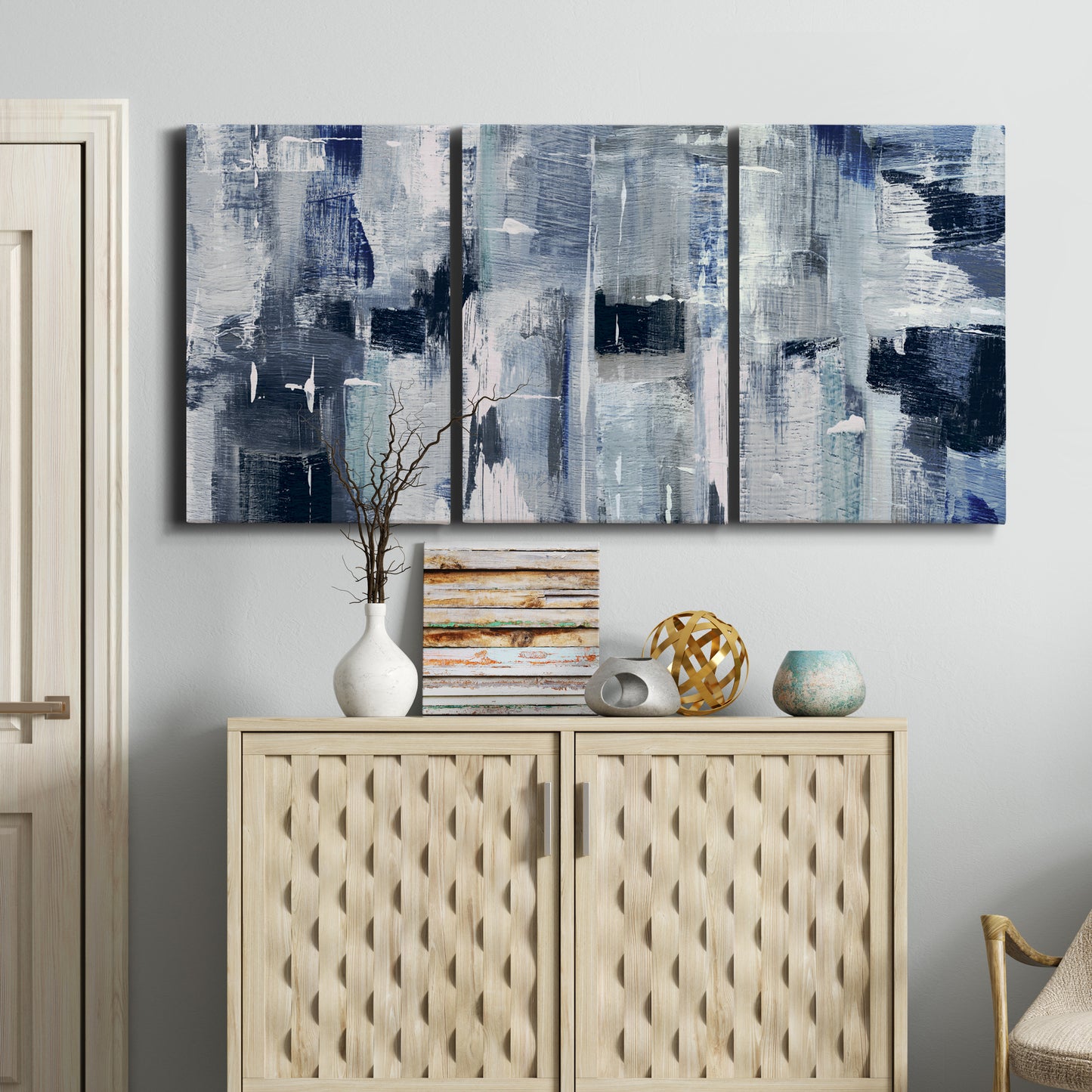 Three-panel canvas wall art featuring soft abstract mountain color fields, displayed above a cabinet in an entryway.