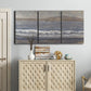 Three-panel canvas wall art featuring shoreline between land and sea, displayed above a cabinet in an entryway.