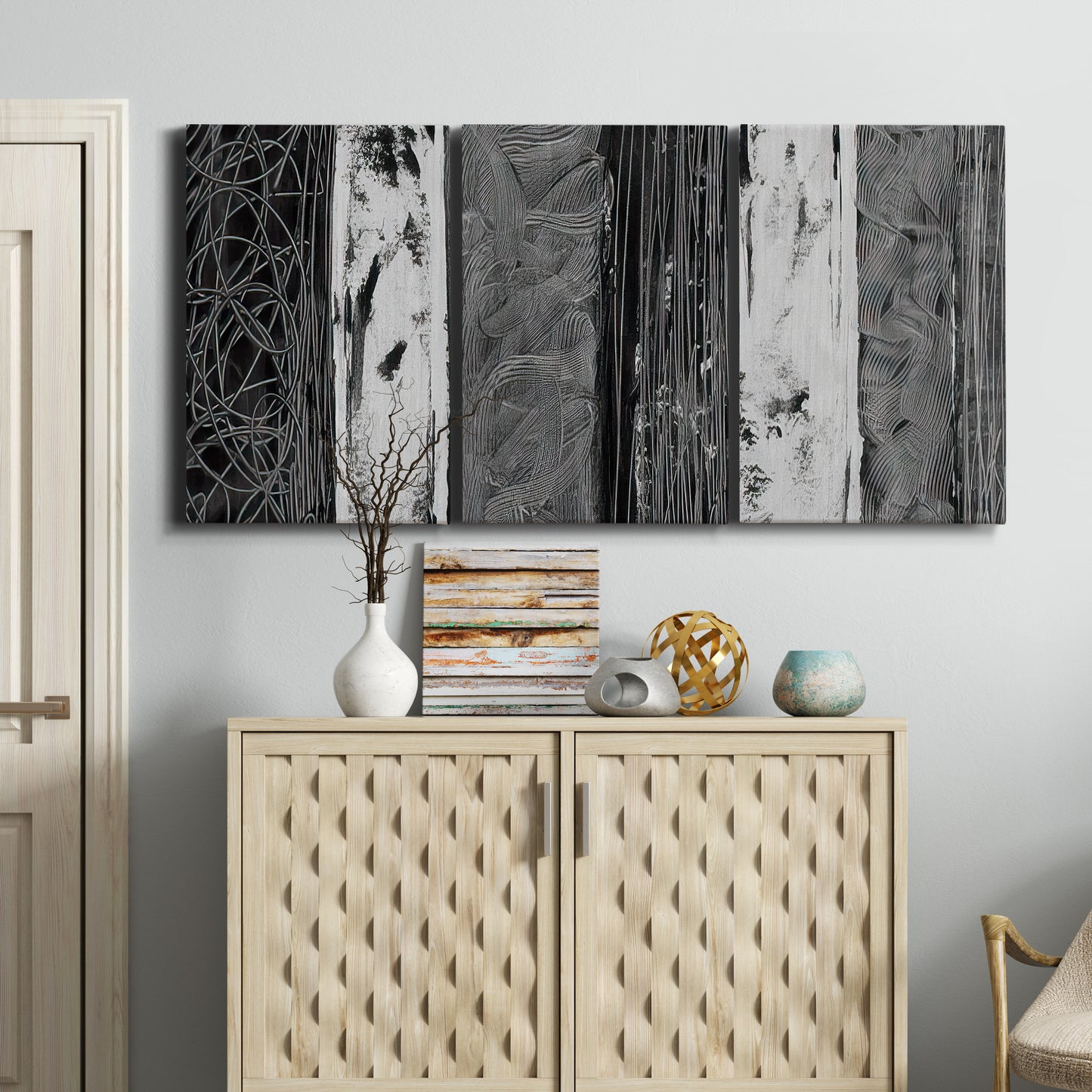 Three-panel canvas wall art featuring brushed metallic abstract textures, displayed above a cabinet in an entryway.