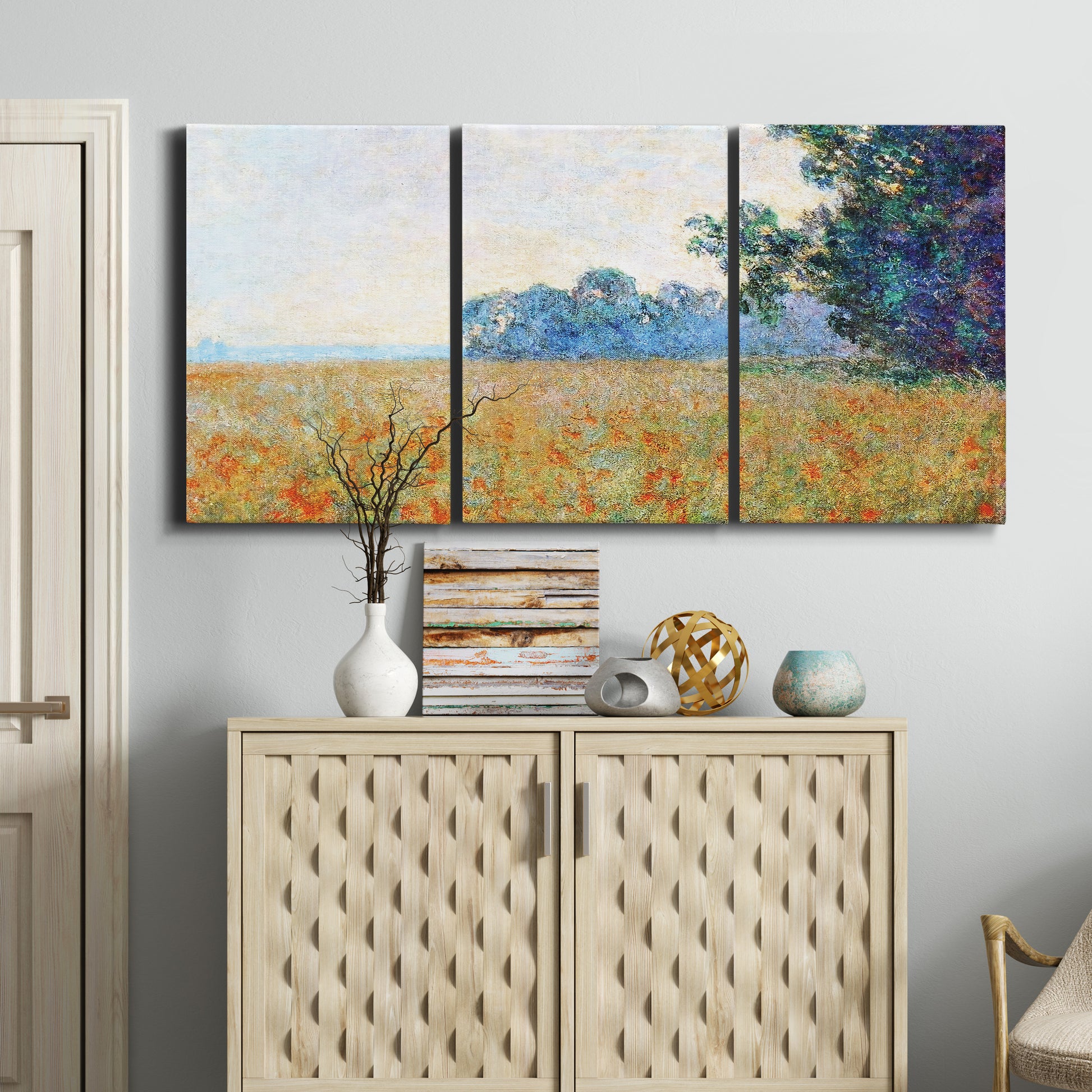 Three-panel canvas wall art featuring oat field with scattered poppies, displayed above a cabinet in an entryway.