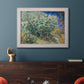 Impressionist lilac flower painting by Vincent van Gogh in an ornate weathered white frame displayed in a dark-toned interior setting.