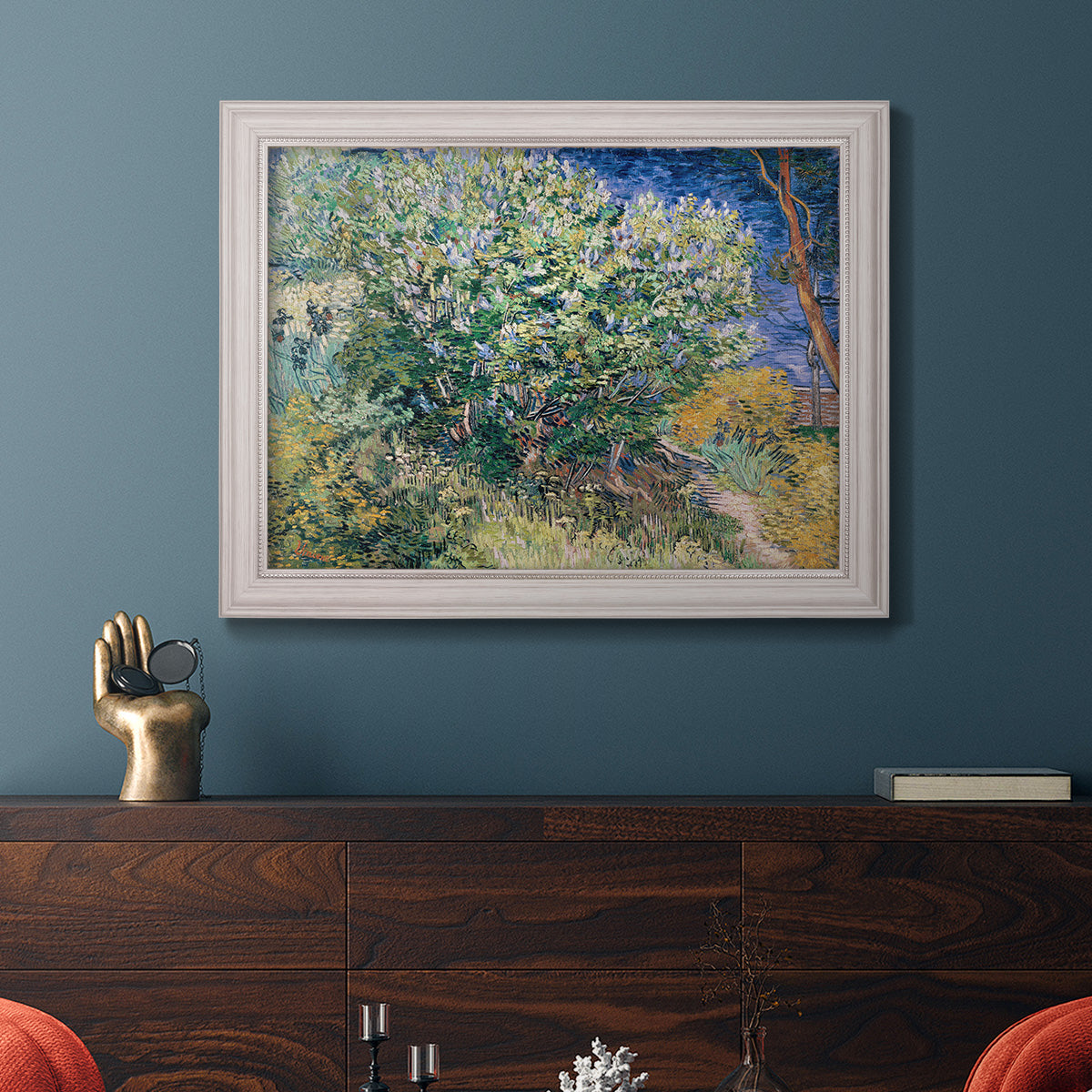 Impressionist lilac flower painting by Vincent van Gogh in an ornate weathered white frame displayed in a dark-toned interior setting.