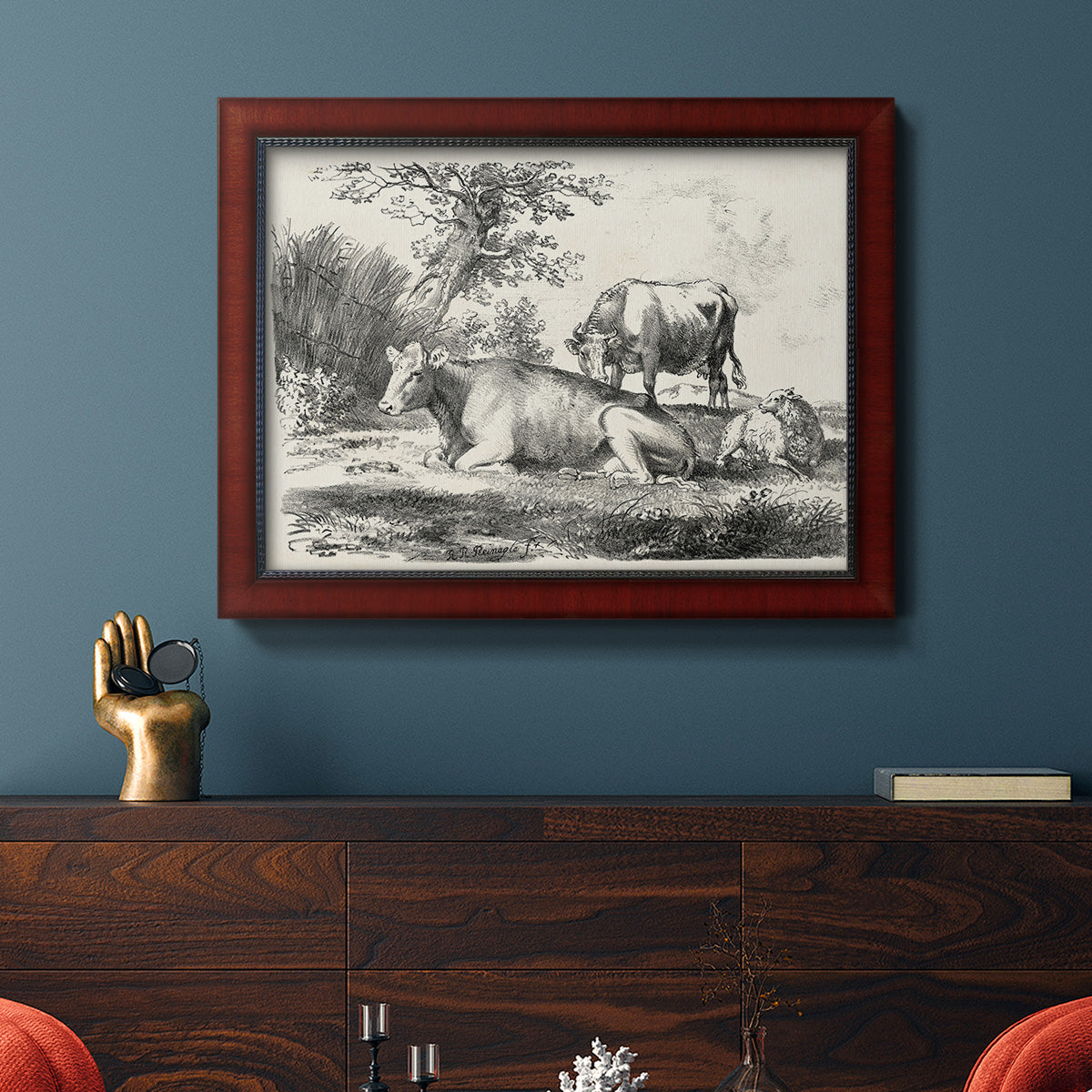Classical pastoral landscape artwork by Nicolas Berchem in an ornate cherry burl wood frame displayed in a dark-toned interior setting.