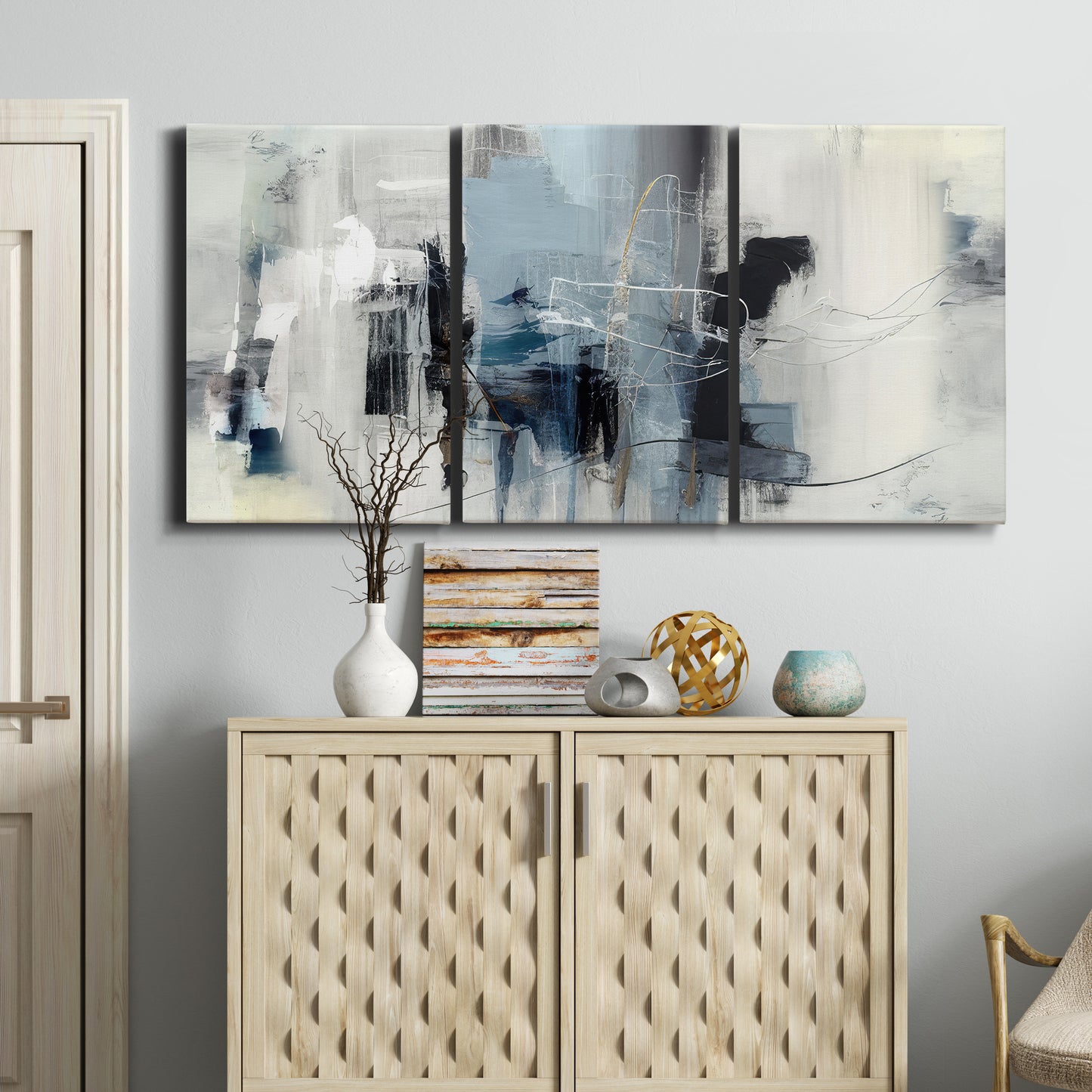 Three-panel canvas wall art featuring cool abstract winter color wash, displayed above a cabinet in an entryway.