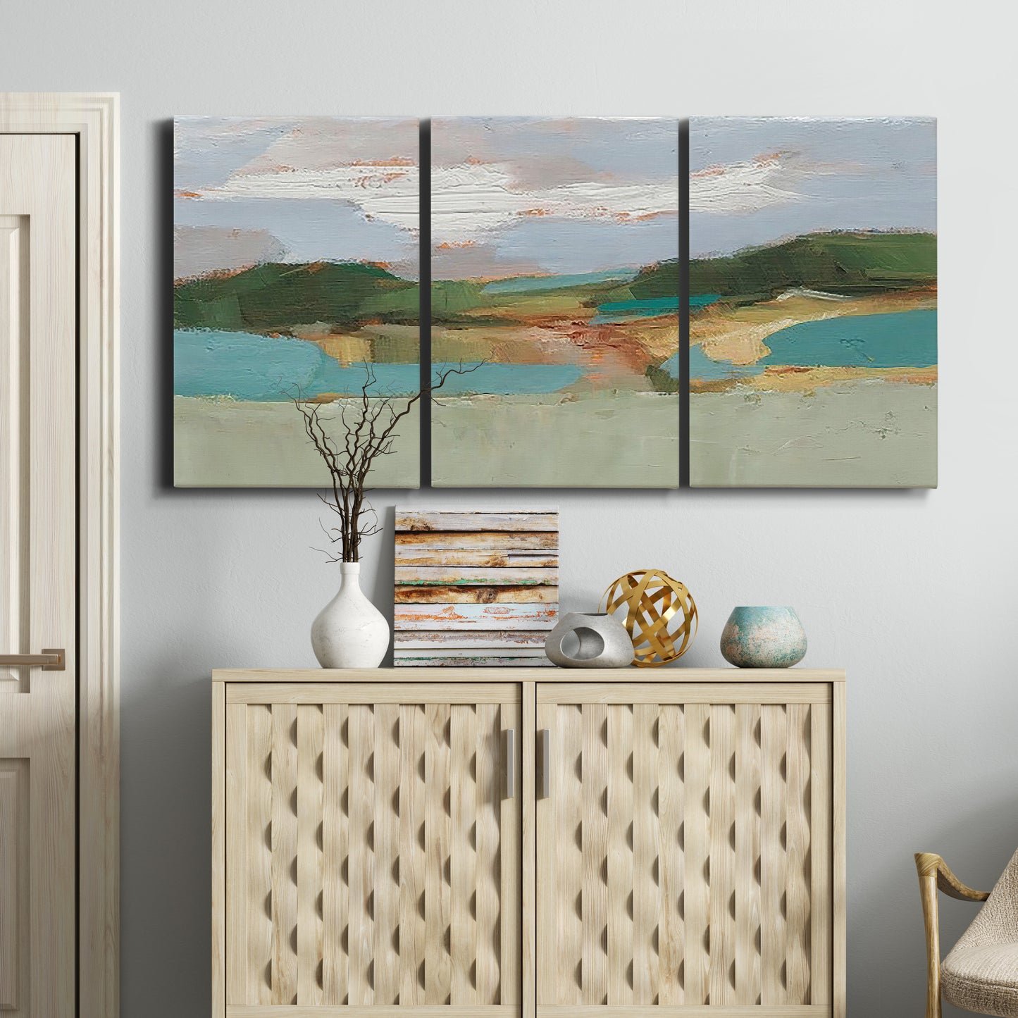 Three-panel canvas wall art featuring wide open landscape under midday light, displayed above a cabinet in an entryway.