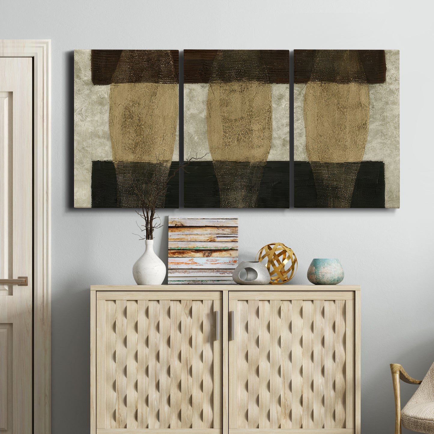 Three-panel canvas wall art featuring textured abstract vessel forms, displayed above a cabinet in an entryway.