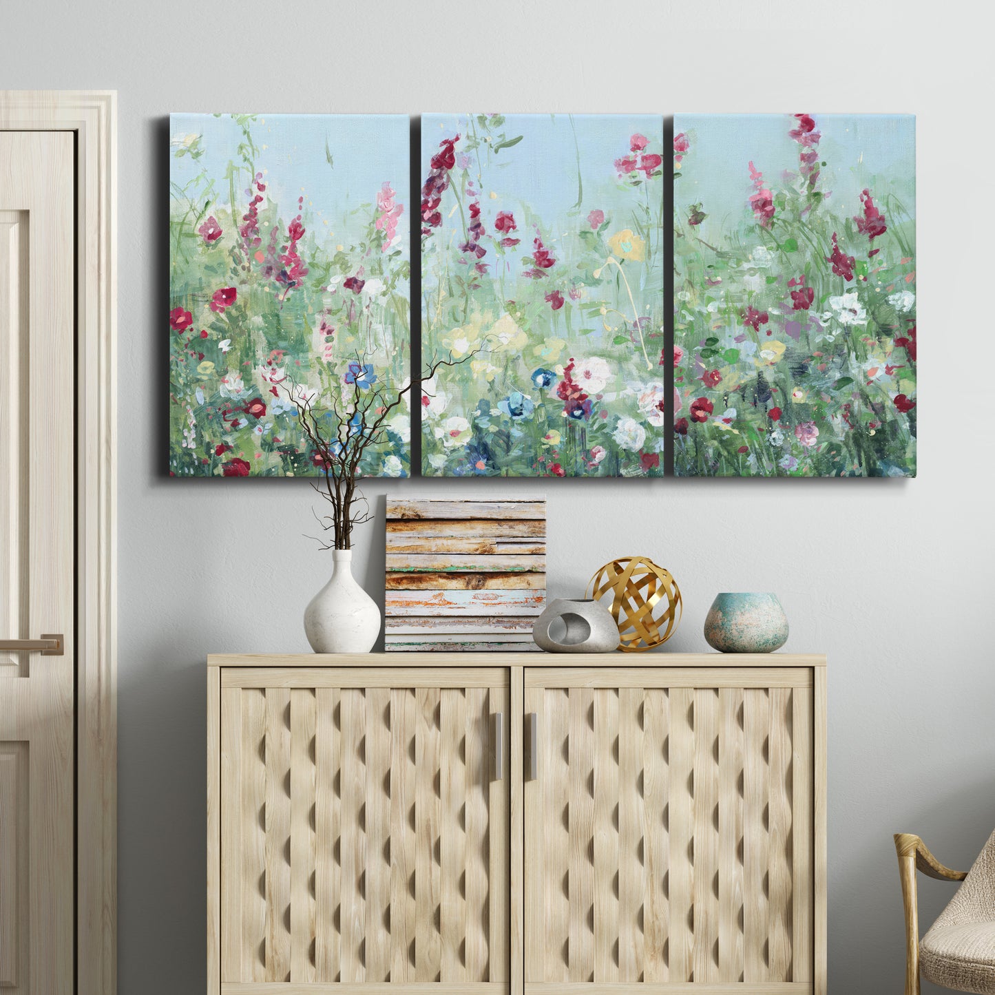 Three-panel canvas wall art featuring night landscape silhouette photography, displayed above a cabinet in an entryway.