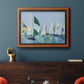 Coastal harbor watercolor painting in an ornate vintage burl wood frame displayed in a dark-toned interior setting.