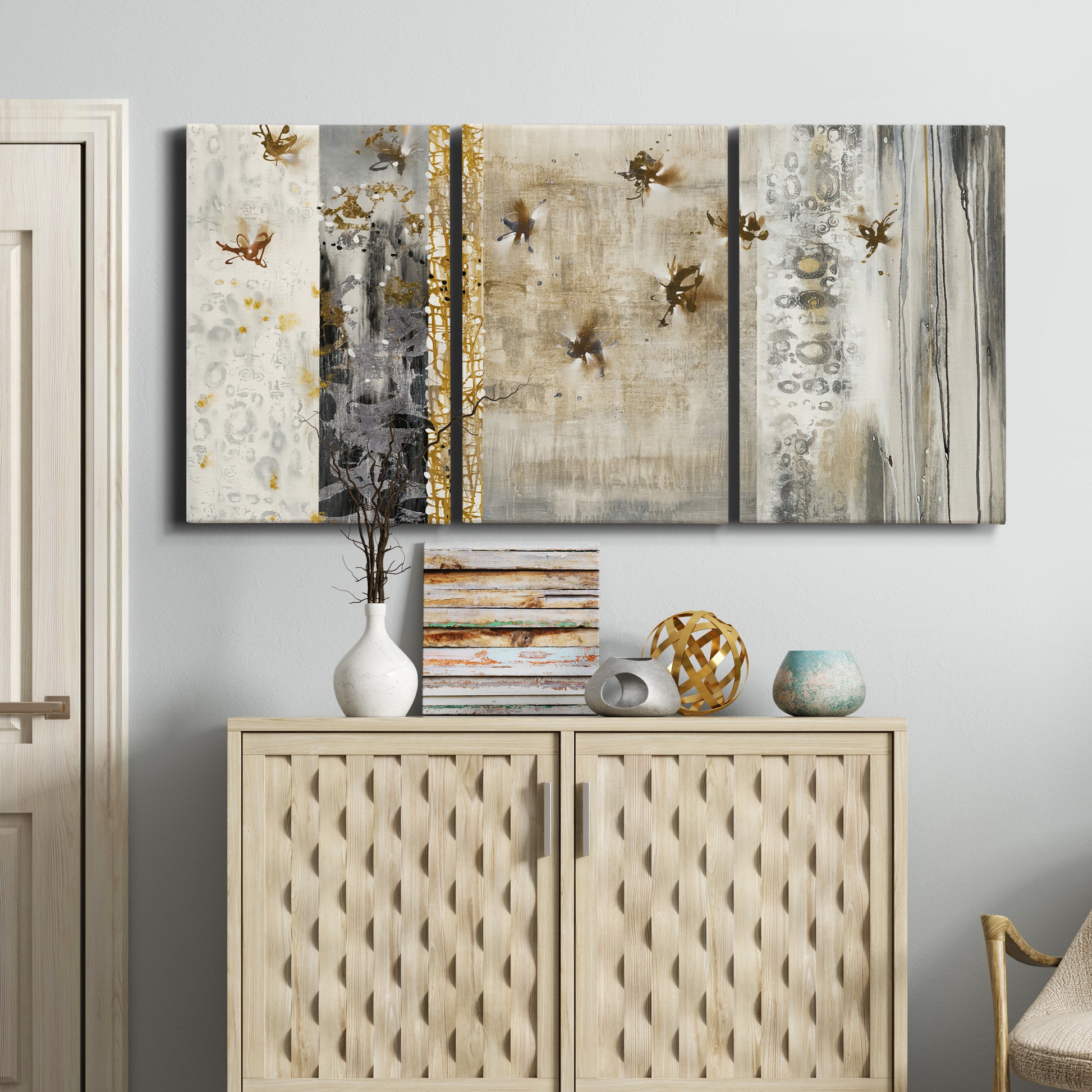 Three-panel canvas wall art featuring abstract willow inspired vertical forms, displayed above a cabinet in an entryway.