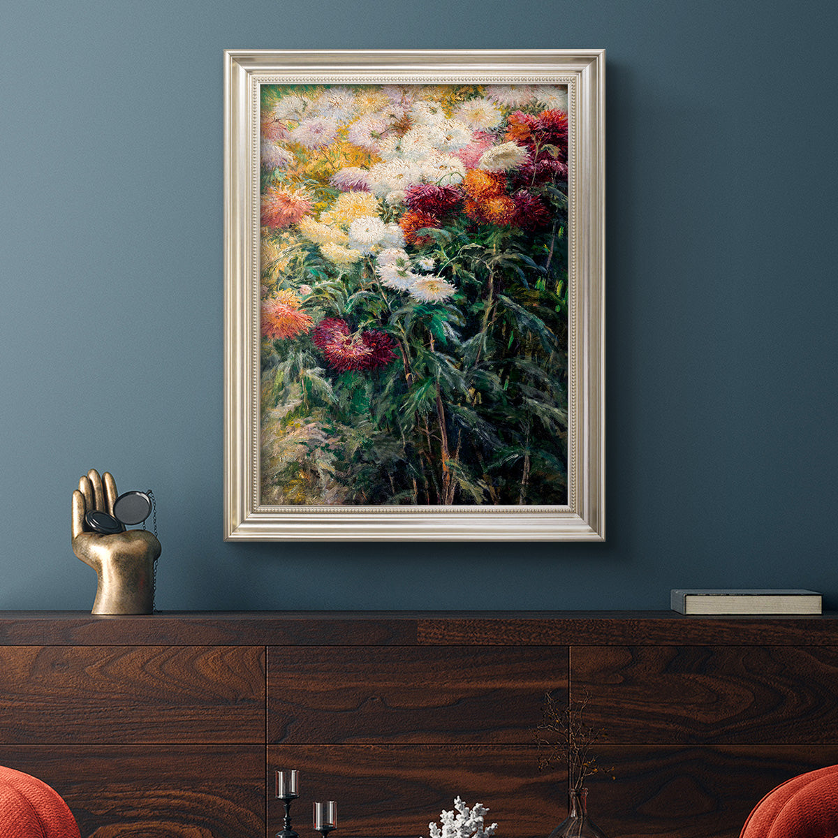 Impressionist garden floral painting by Gustave Caillebotte in an ornate champagne frame displayed in a dark-toned interior setting.