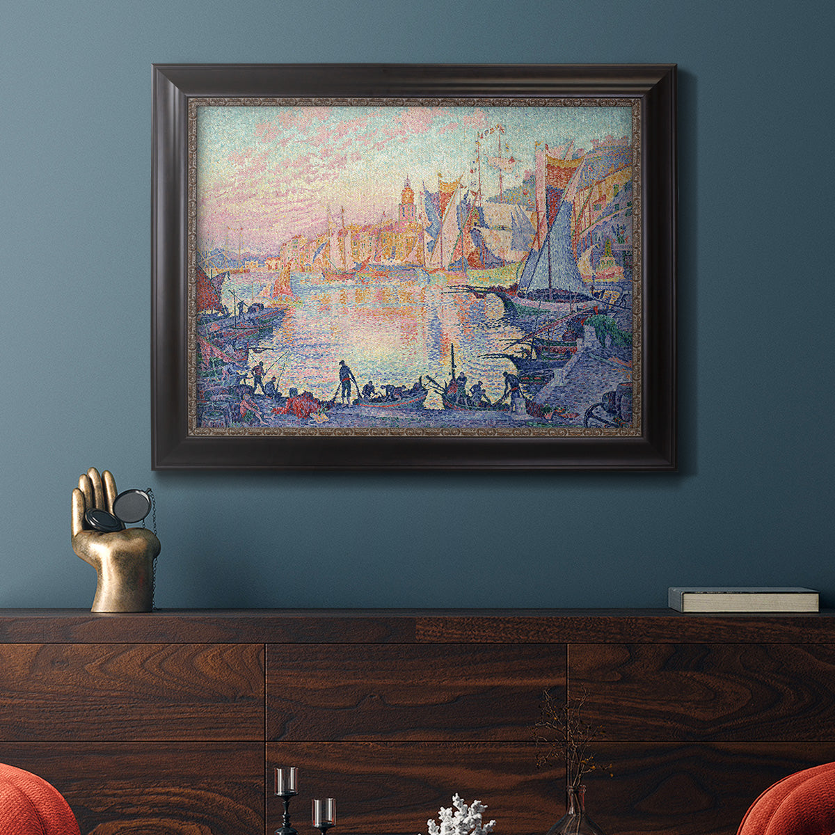 Impressionist Mediterranean harbor painting by Paul Signac in an ornate black frame with gilded inner detail displayed in a dark-toned interior setting.