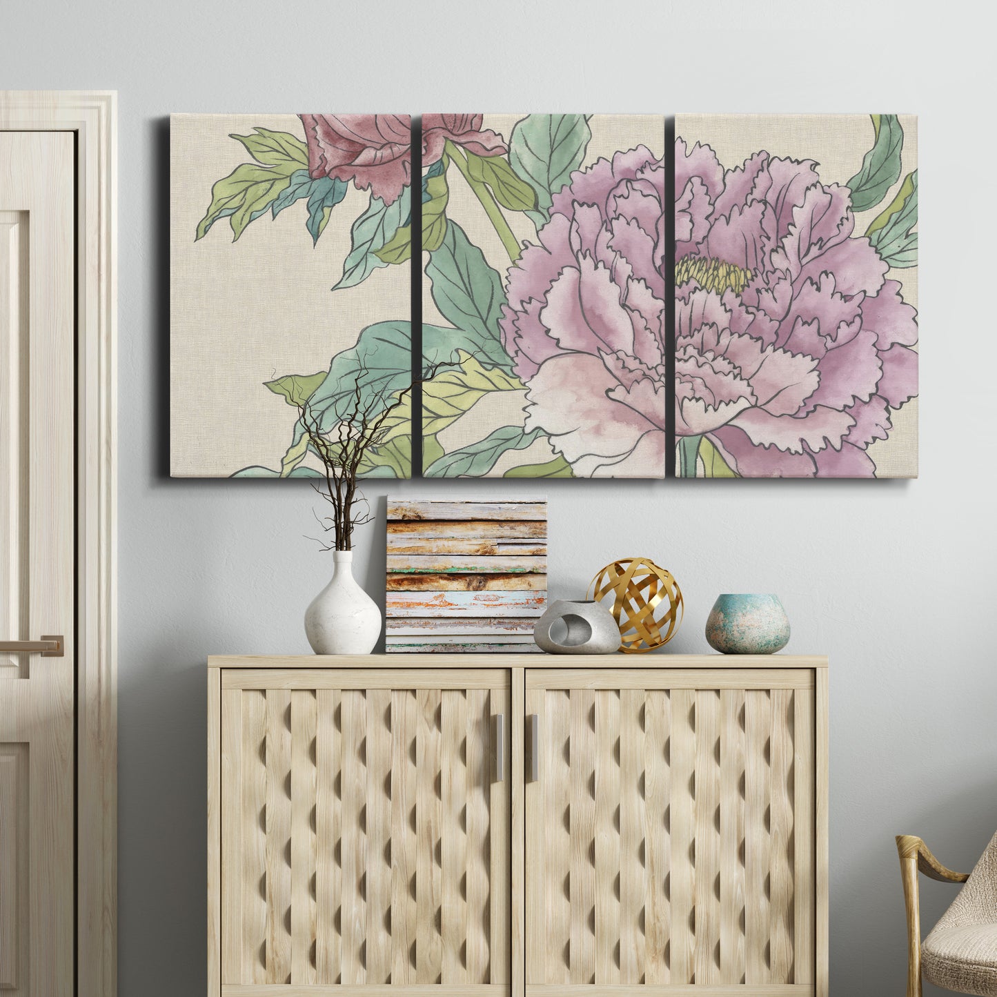 Three-panel canvas wall art featuring soft pink peony blossoms, displayed above a cabinet in an entryway.