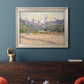 Impressionist valley landscape in southern France by Claude Monet in an ornate champagne frame displayed in a dark-toned interior setting.