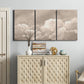 Three-panel canvas wall art featuring soft whimsical cloudscape, displayed above a cabinet in an entryway.