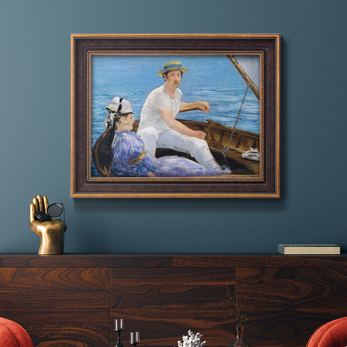 Impressionist leisure boating scene by Édouard Manet in an ornate bronzed mahogany wood frame displayed in a dark-toned interior setting.