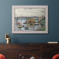 Impressionist river bridge scene on an overcast day by Claude Monet in an ornate weathered white frame displayed in a dark-toned interior setting.