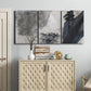Three-panel canvas wall art featuring dark abstract atmospheric landscape, displayed above a cabinet in an entryway.