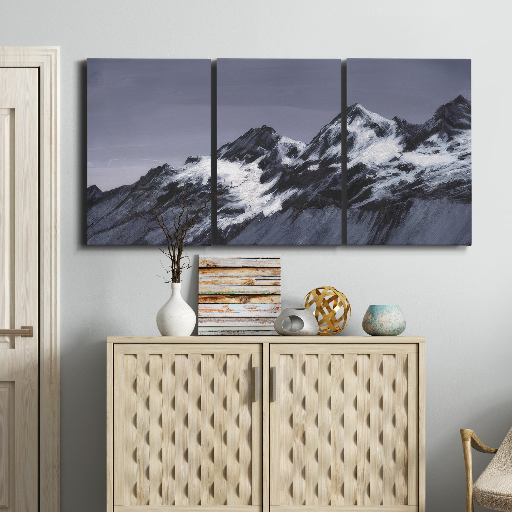 Three-panel canvas wall art featuring moonlit mountain peaks under night sky, displayed above a cabinet in an entryway.