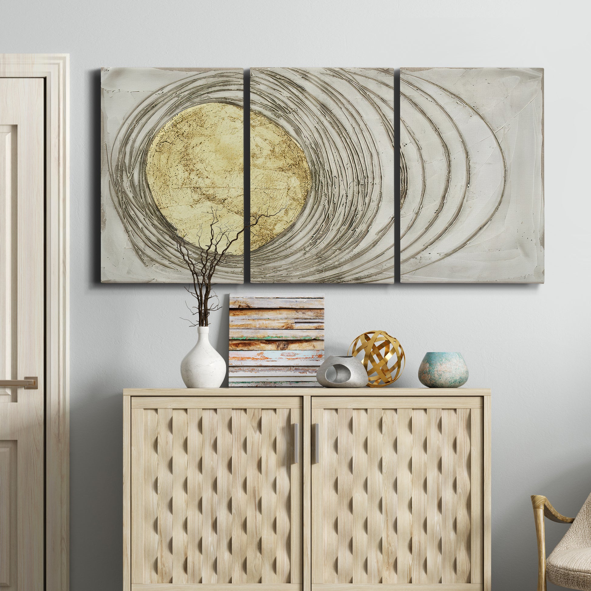 Three-panel canvas wall art featuring circular abstract energy forms, displayed above a cabinet in an entryway.