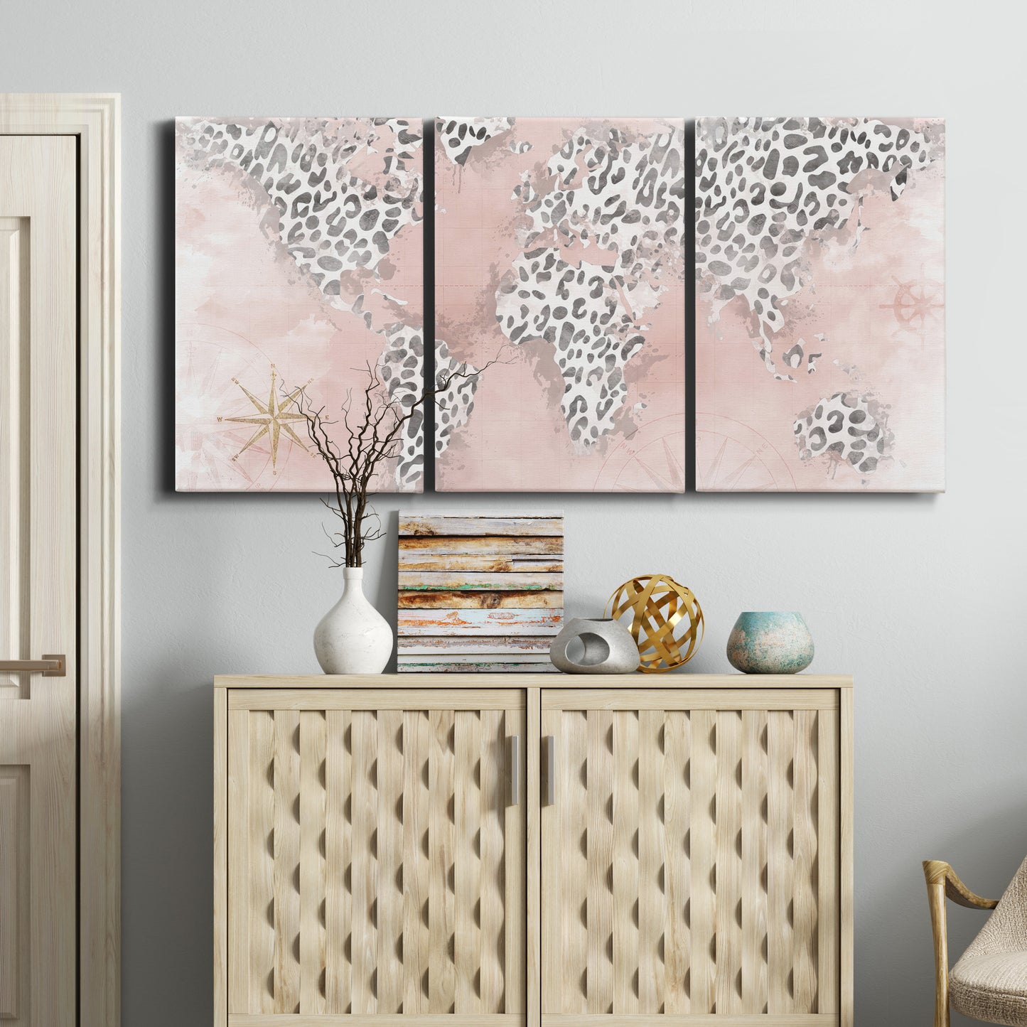 Three-panel canvas wall art featuring stylized pink cheetah world map, displayed above a cabinet in an entryway.