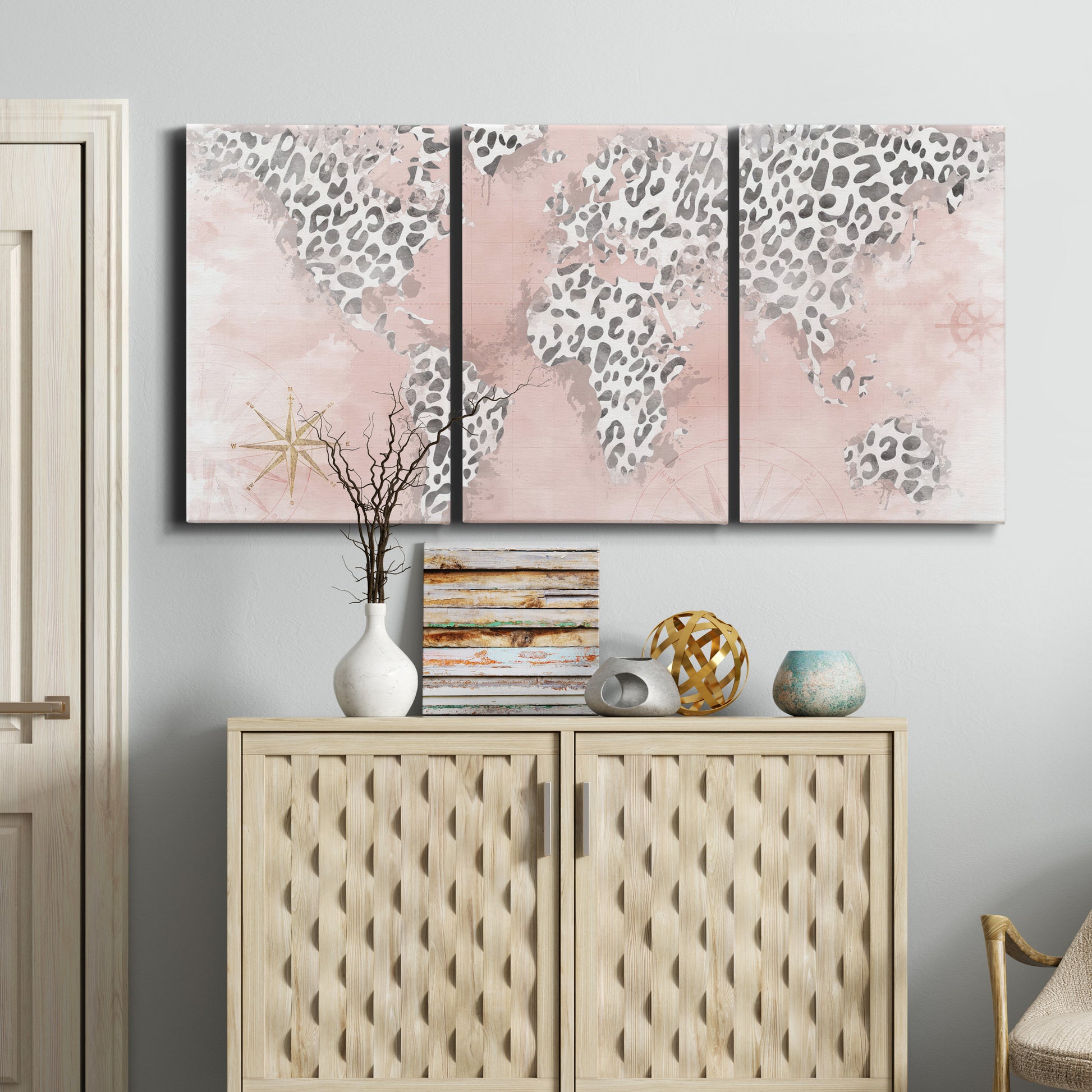Three-panel canvas wall art featuring stylized pink cheetah world map, displayed above a cabinet in an entryway.