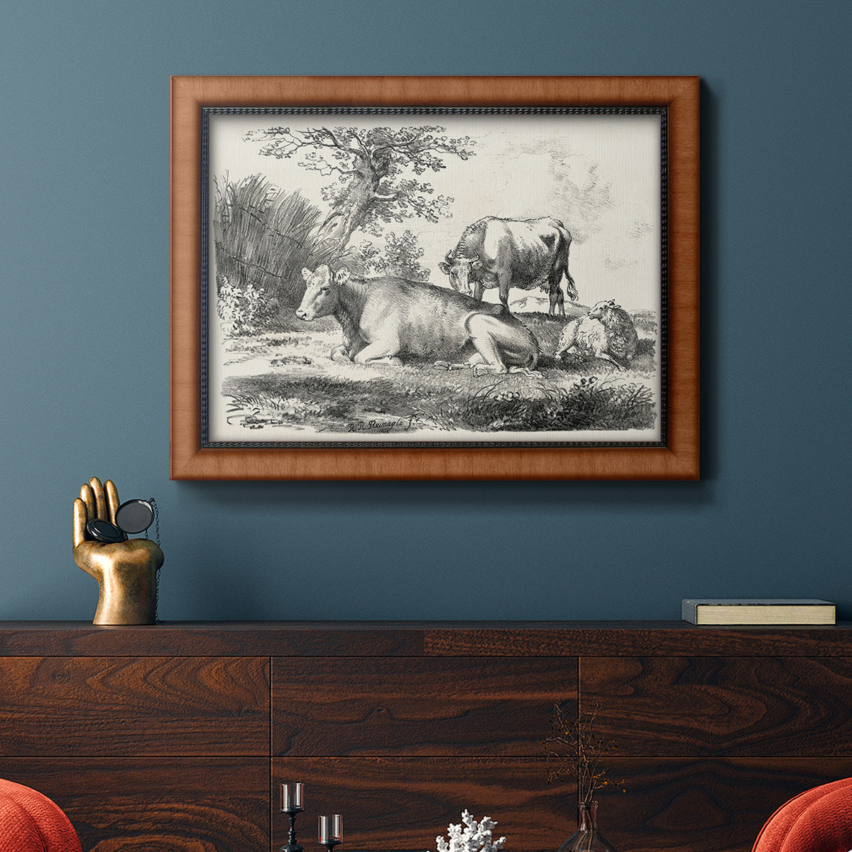 Classical pastoral landscape artwork by Nicolas Berchem in an ornate vintage burl wood frame displayed in a dark-toned interior setting.