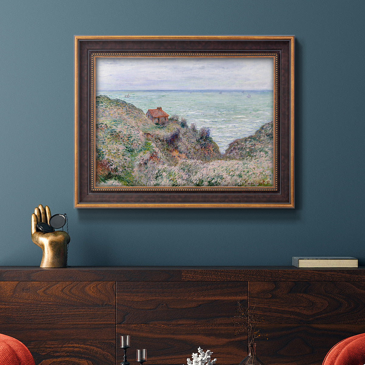Impressionist coastal watch cabin scene by Claude Monet in an ornate bronzed mahogany wood frame displayed in a dark-toned interior setting.