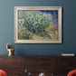Impressionist lilac flower painting by Vincent van Gogh in an ornate champagne frame displayed in a dark-toned interior setting.